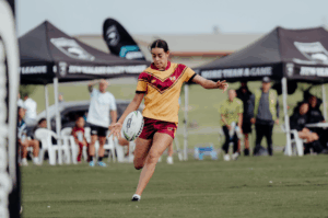 Female rugby league player kicking ball